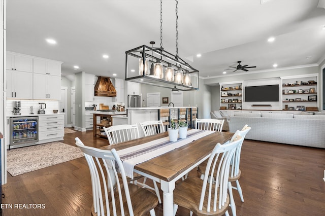 dining room featuring ornamental molding, wine cooler, ceiling fan, and dark wood-type flooring