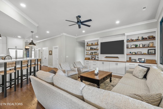 living room with hardwood / wood-style flooring, ceiling fan, and ornamental molding