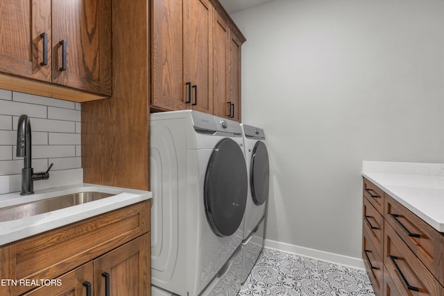 laundry area featuring cabinets, independent washer and dryer, sink, and light tile patterned floors