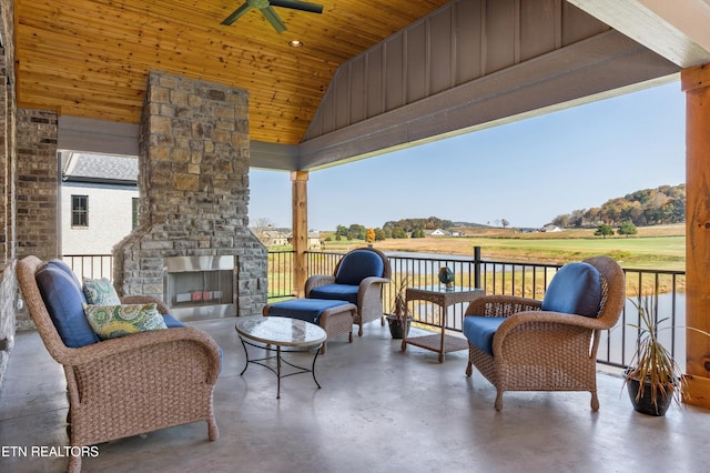 view of patio with an outdoor stone fireplace and ceiling fan