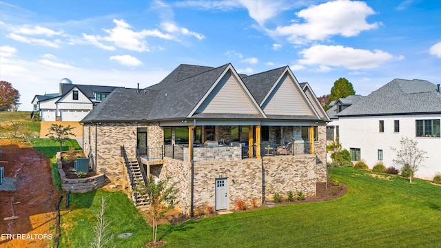 rear view of house featuring a balcony and a lawn