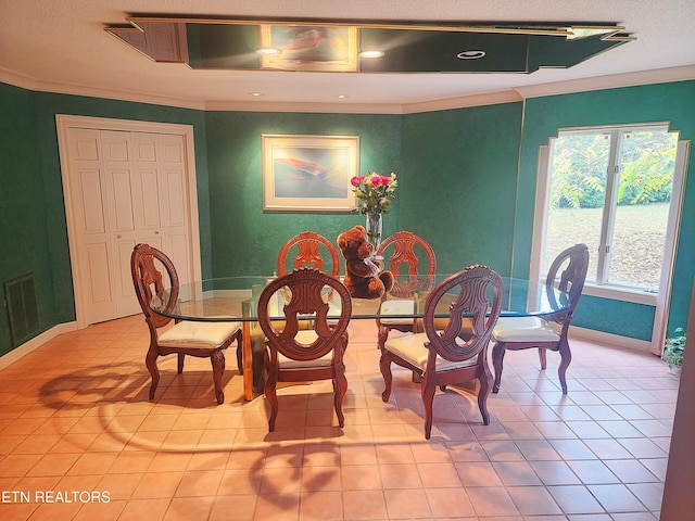 tiled dining space with a textured ceiling and crown molding