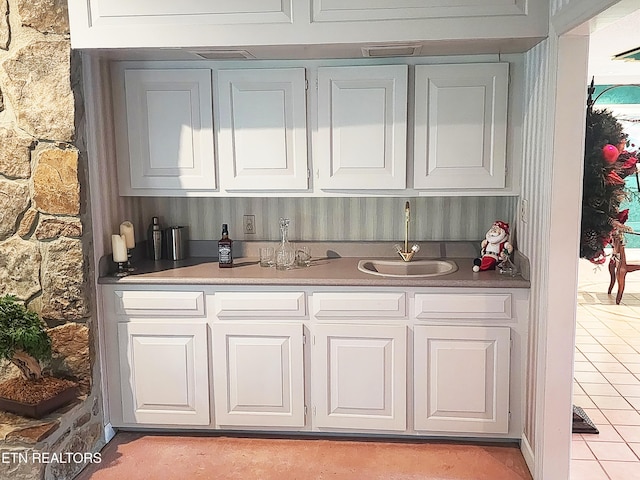 bar with light tile patterned flooring and sink