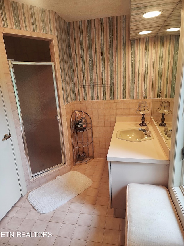 bathroom with tile patterned flooring, vanity, and walk in shower