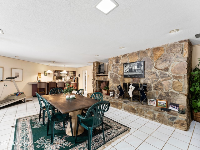 tiled dining space featuring a fireplace and a textured ceiling