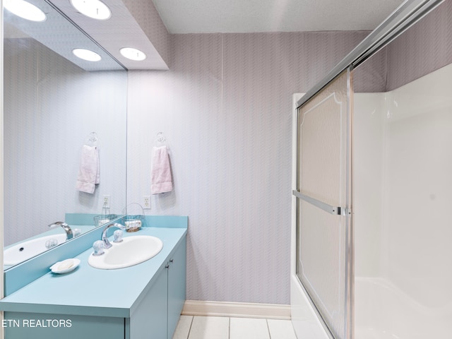 bathroom featuring tile patterned flooring, vanity, and combined bath / shower with glass door