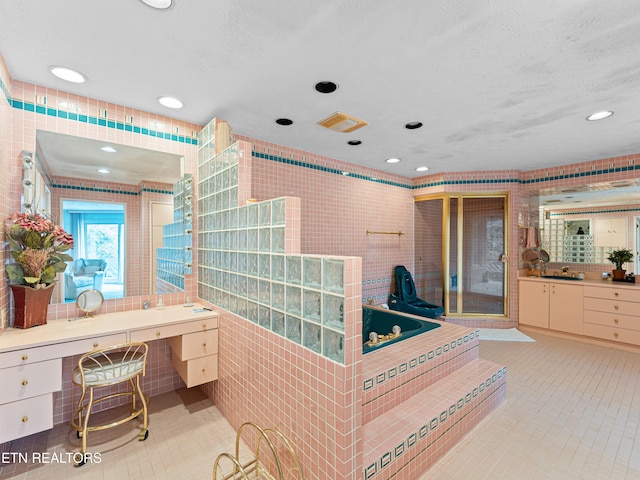 bathroom with a washtub, a textured ceiling, and vanity