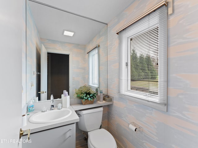 bathroom with vanity, toilet, and tile walls