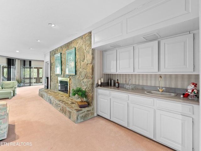 interior space featuring light carpet, sink, and white cabinets