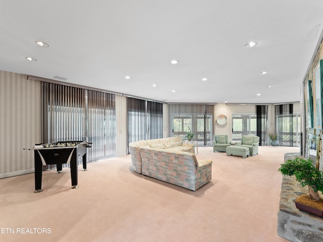 living room with expansive windows and light carpet