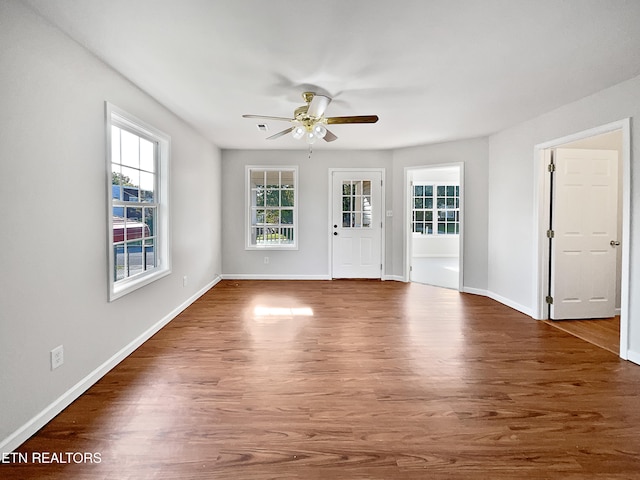 empty room featuring dark wood-type flooring and ceiling fan