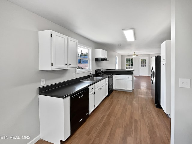 kitchen featuring black appliances, kitchen peninsula, white cabinetry, light hardwood / wood-style floors, and ceiling fan