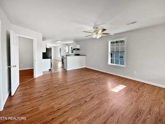 unfurnished living room featuring hardwood / wood-style flooring and ceiling fan