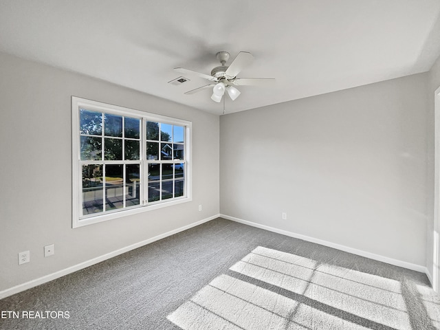 carpeted spare room featuring ceiling fan