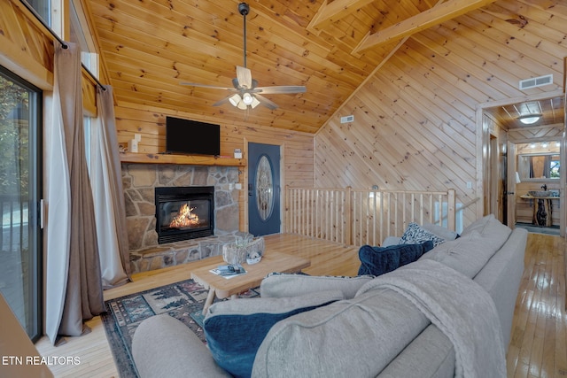 living room featuring light hardwood / wood-style flooring, wooden walls, and high vaulted ceiling