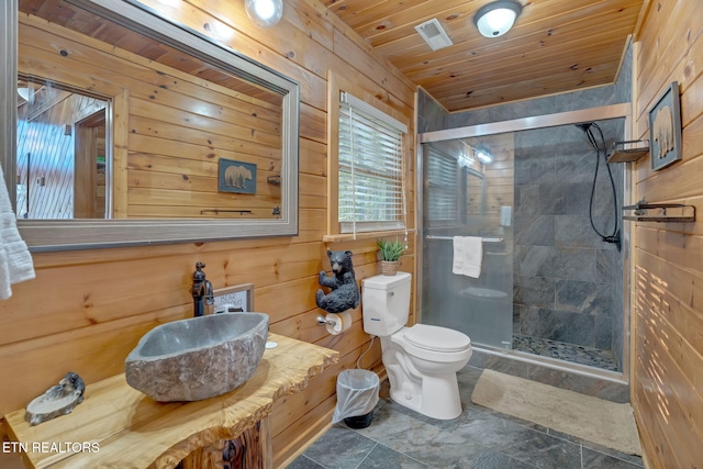 bathroom with toilet, a shower with shower door, wooden walls, and vanity