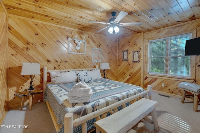 bedroom featuring wood walls, carpet flooring, wooden ceiling, and ceiling fan