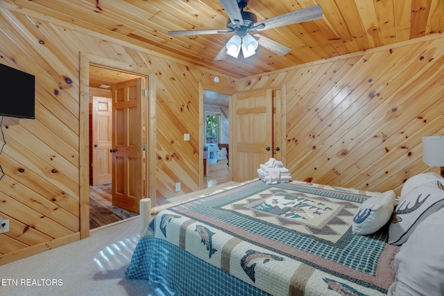 bedroom featuring wood ceiling, wooden walls, carpet, and ceiling fan