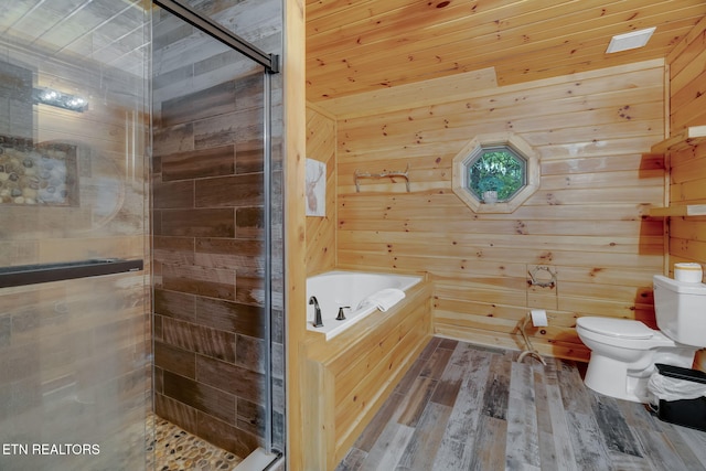 bathroom featuring wooden walls, shower with separate bathtub, hardwood / wood-style flooring, and toilet