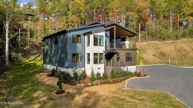 contemporary home featuring a front yard and a balcony