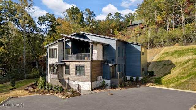 view of front facade with a balcony and a front lawn