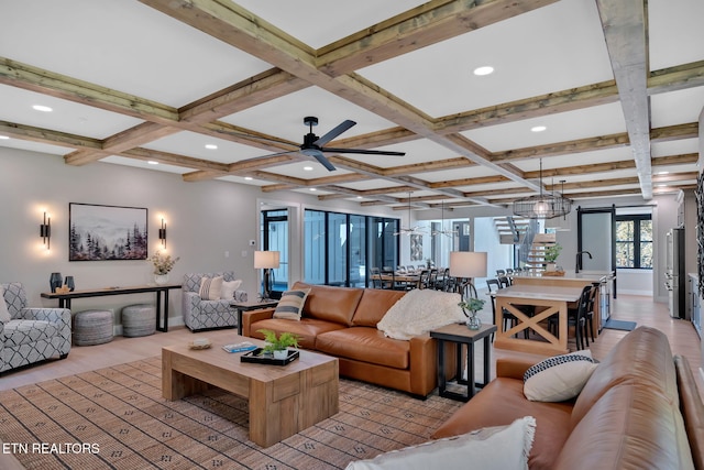 living room with beam ceiling, coffered ceiling, and ceiling fan