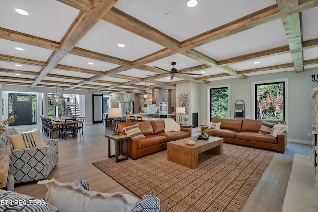 living room with beamed ceiling, coffered ceiling, and light wood-type flooring