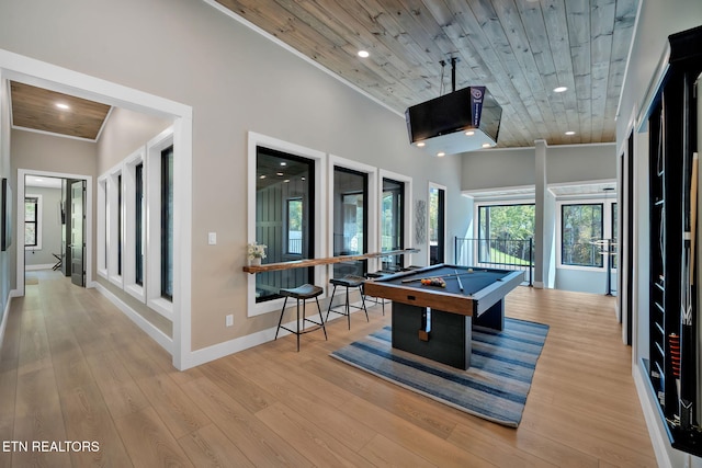 game room with pool table, light hardwood / wood-style flooring, wooden ceiling, and a high ceiling