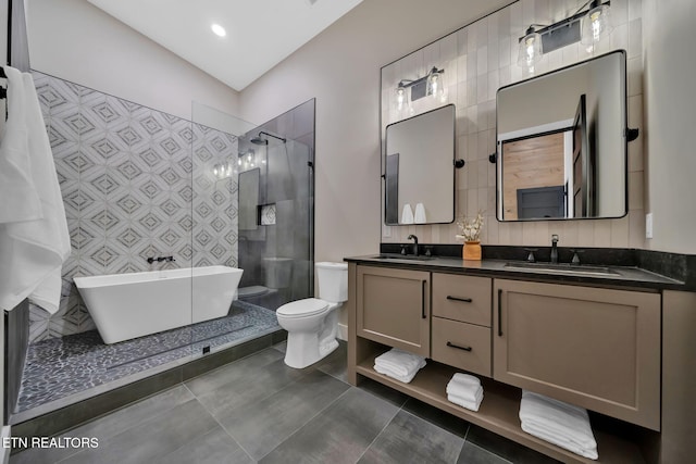 full bathroom featuring independent shower and bath, toilet, tile patterned floors, tile walls, and vanity