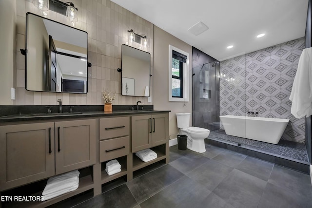 full bathroom featuring toilet, shower with separate bathtub, vanity, and tile walls