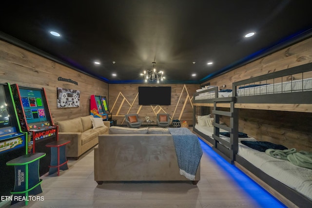 cinema room with hardwood / wood-style floors, a notable chandelier, and wood walls