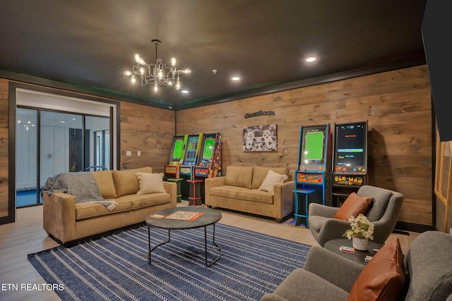 living room with a chandelier, wooden walls, and light hardwood / wood-style floors