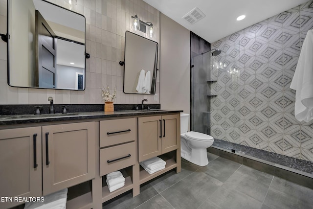 bathroom with toilet, walk in shower, vanity, and tile walls