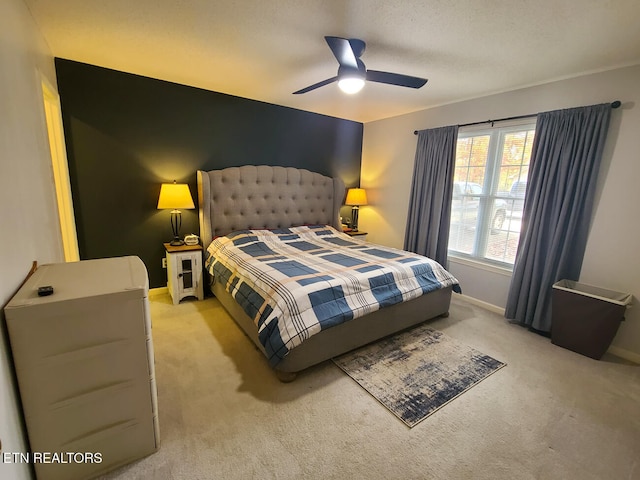 bedroom featuring ceiling fan, a textured ceiling, and light colored carpet