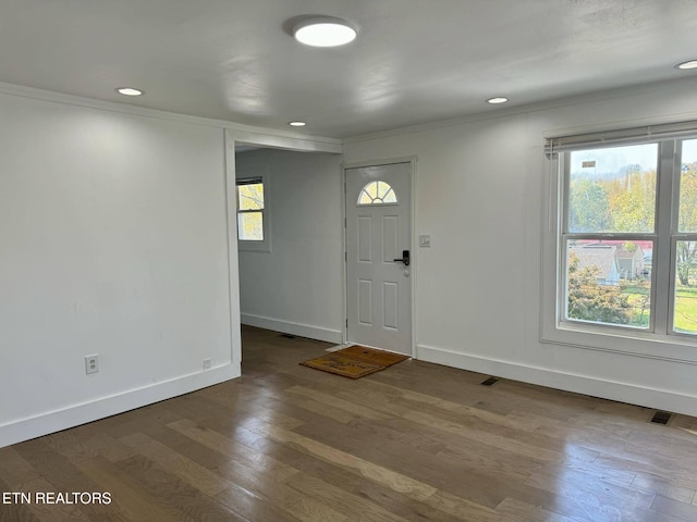 entryway with dark hardwood / wood-style flooring, plenty of natural light, and ornamental molding