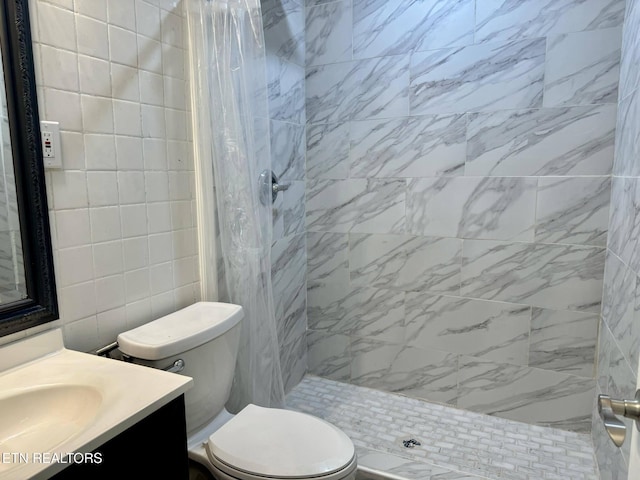 bathroom with vanity, curtained shower, toilet, and tile walls