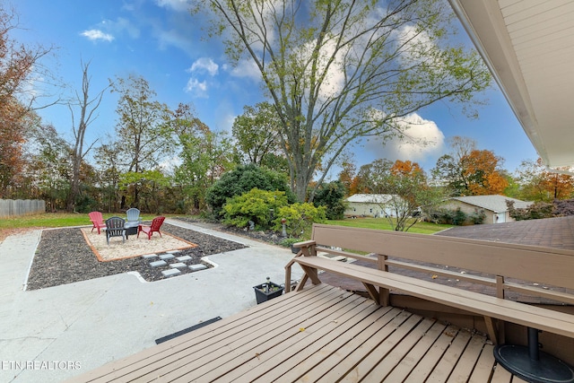 wooden deck with an outdoor fire pit and a patio