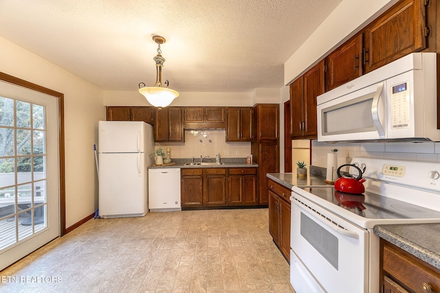 kitchen featuring sink, tasteful backsplash, pendant lighting, white appliances, and light wood-type flooring