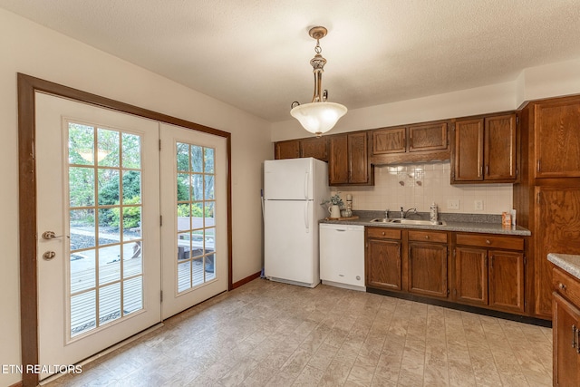 kitchen with sink, backsplash, light hardwood / wood-style flooring, white appliances, and decorative light fixtures