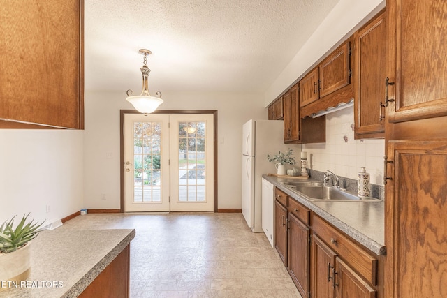 kitchen featuring a textured ceiling, sink, decorative light fixtures, and tasteful backsplash