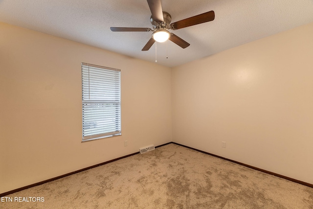 spare room with ceiling fan, a textured ceiling, and carpet floors