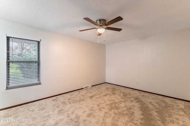 carpeted spare room with a textured ceiling and ceiling fan