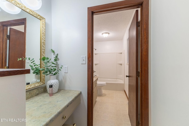 full bathroom featuring vanity, a textured ceiling, toilet, and shower / bath combination