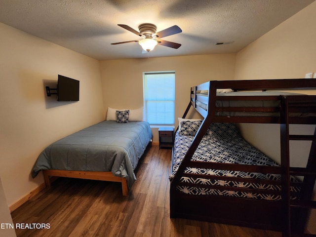 bedroom featuring dark hardwood / wood-style floors, a textured ceiling, and ceiling fan