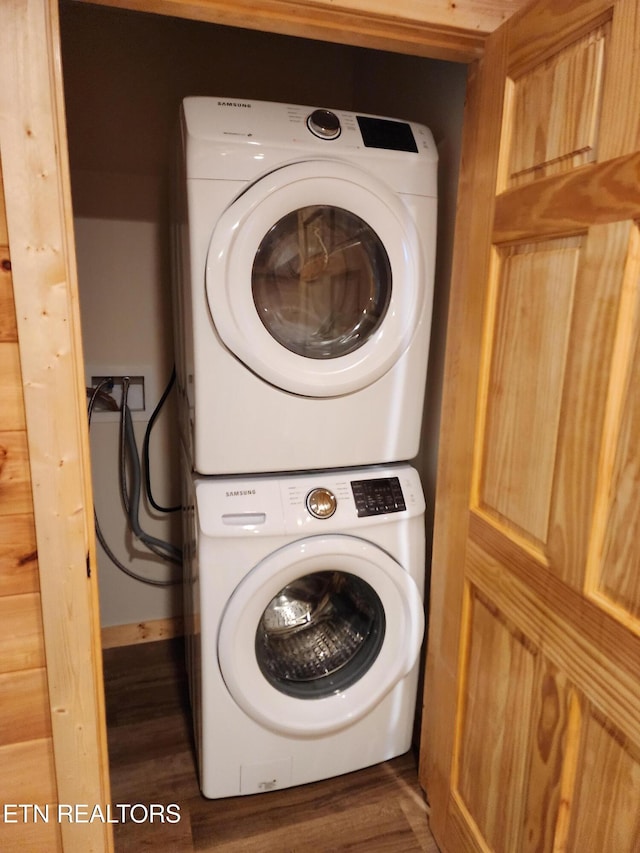 clothes washing area featuring stacked washer / dryer and dark hardwood / wood-style floors