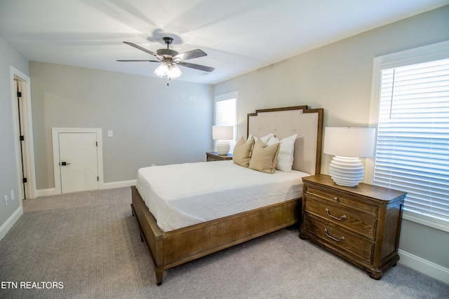 carpeted bedroom with ceiling fan and multiple windows