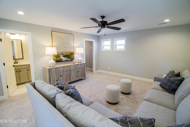 living room featuring ceiling fan, sink, and light carpet