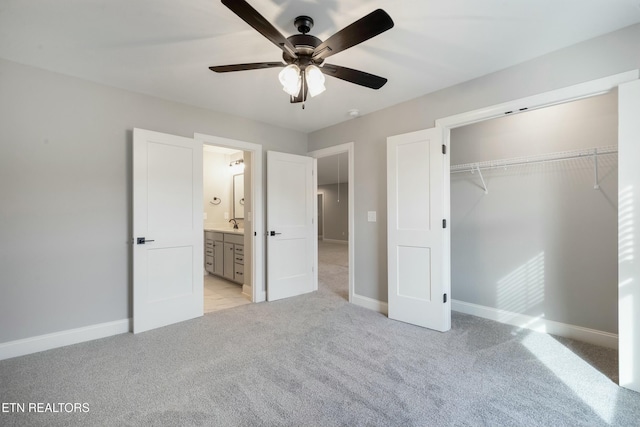 unfurnished bedroom with ensuite bath, ceiling fan, a closet, and light colored carpet