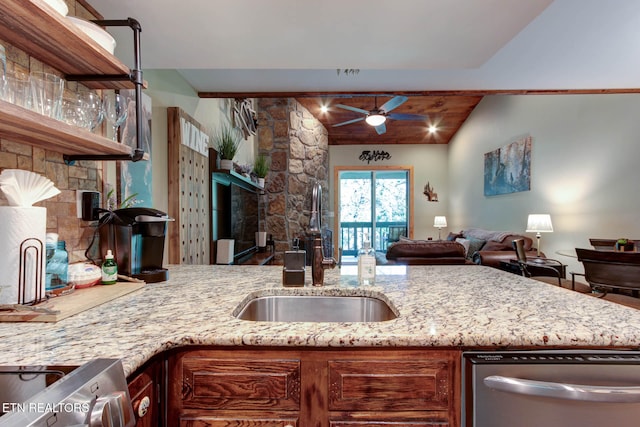 kitchen with ceiling fan, lofted ceiling, sink, and light stone counters