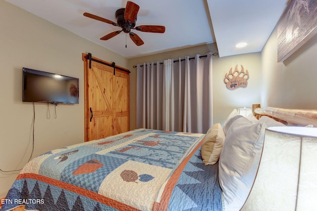 bedroom with a barn door and ceiling fan